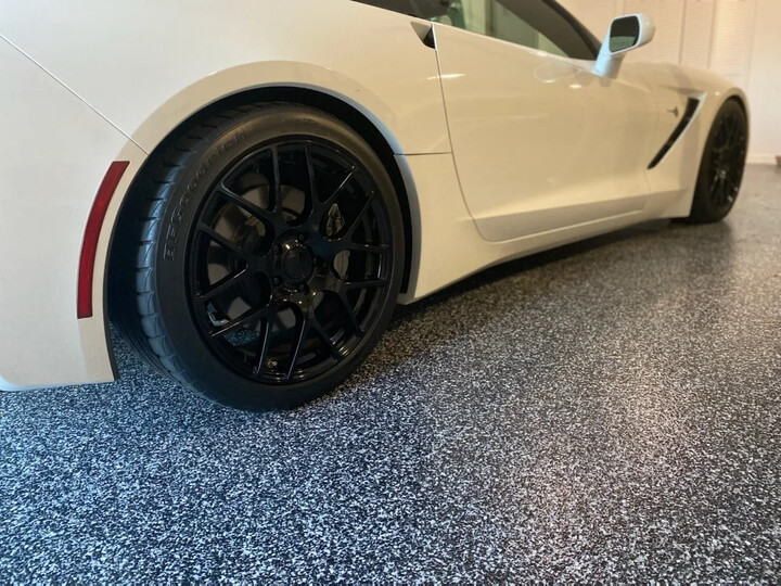 Flake garage floor coating with a sports car