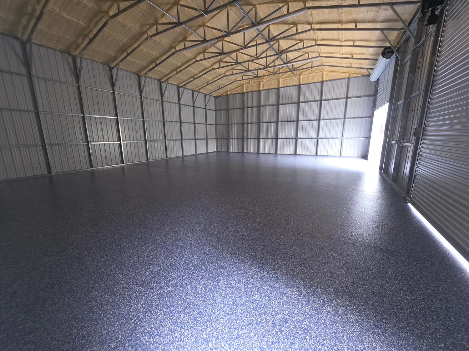 Flake coated metal building floor seen from the open bay door