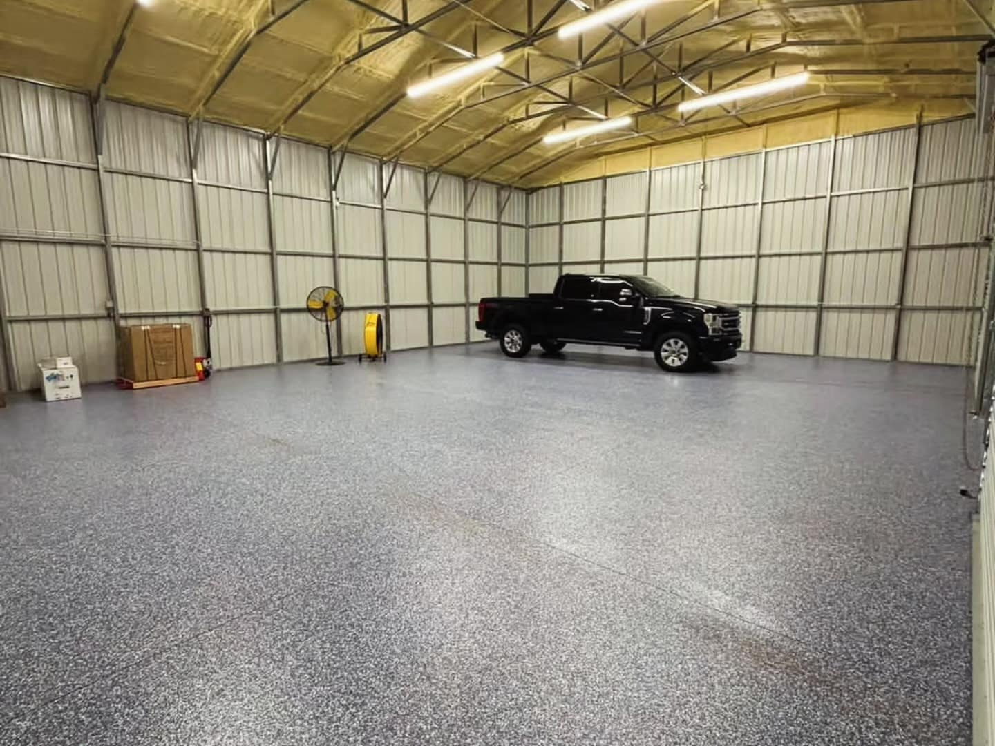 Finished flake floor in a metal building with a pickup truck parked on it