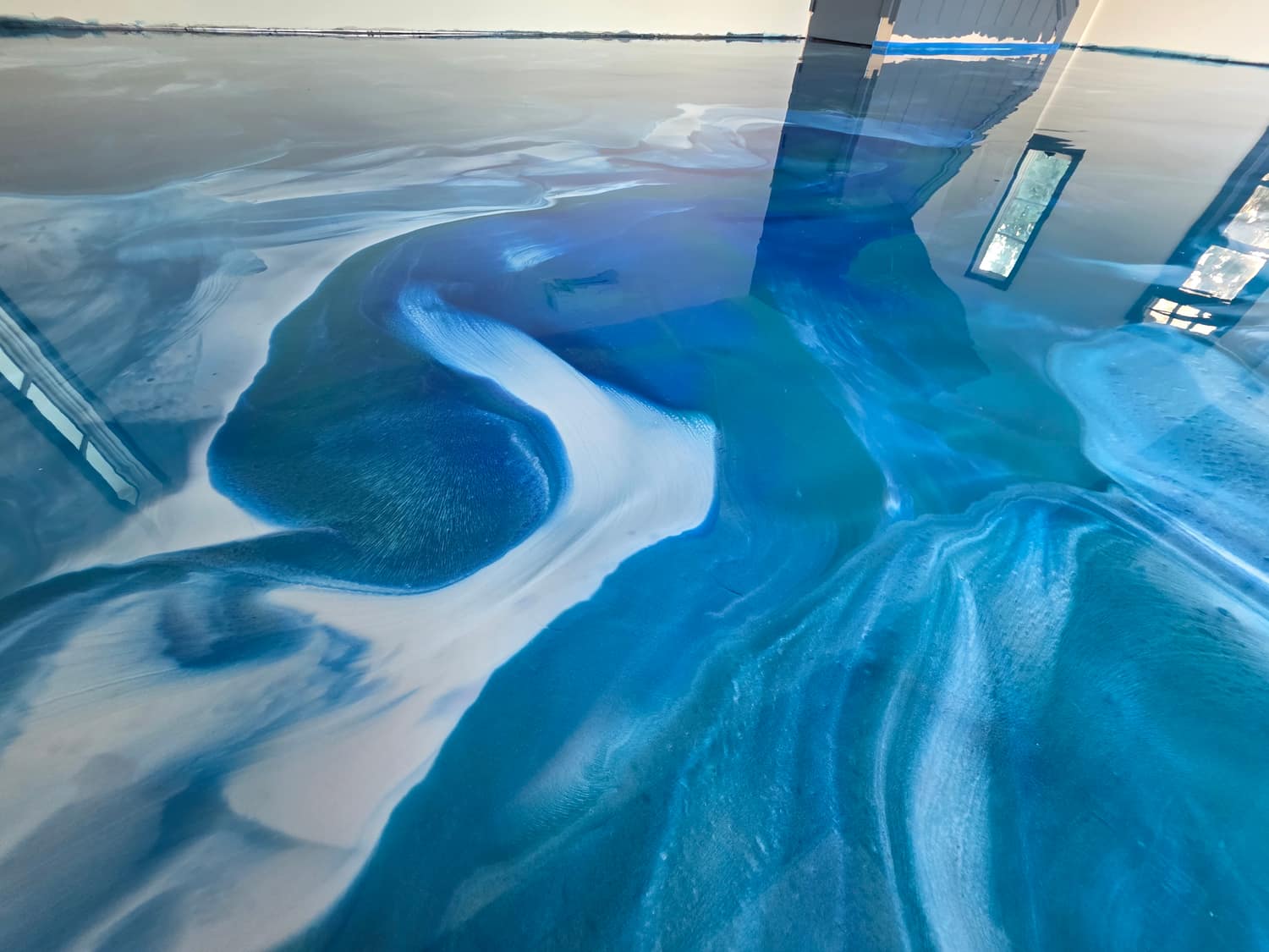 Close-up of a blue and white metallic epoxy floor with a wave pattern