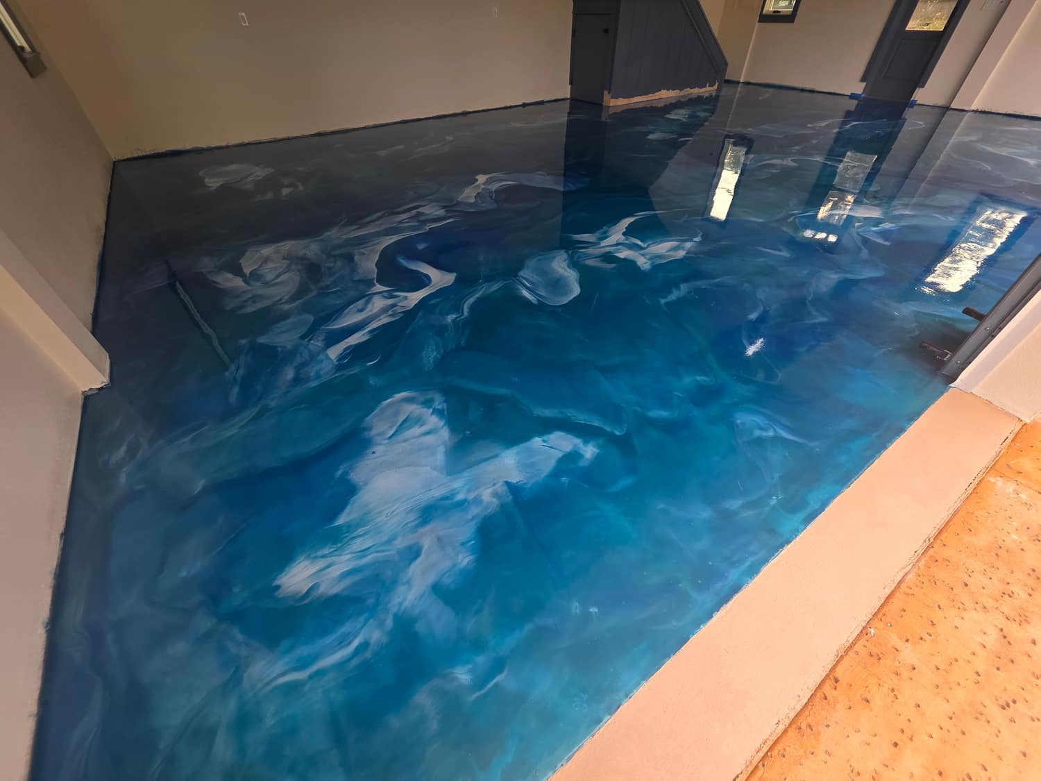Deep blue metallic epoxy floor poured in a residential interior room