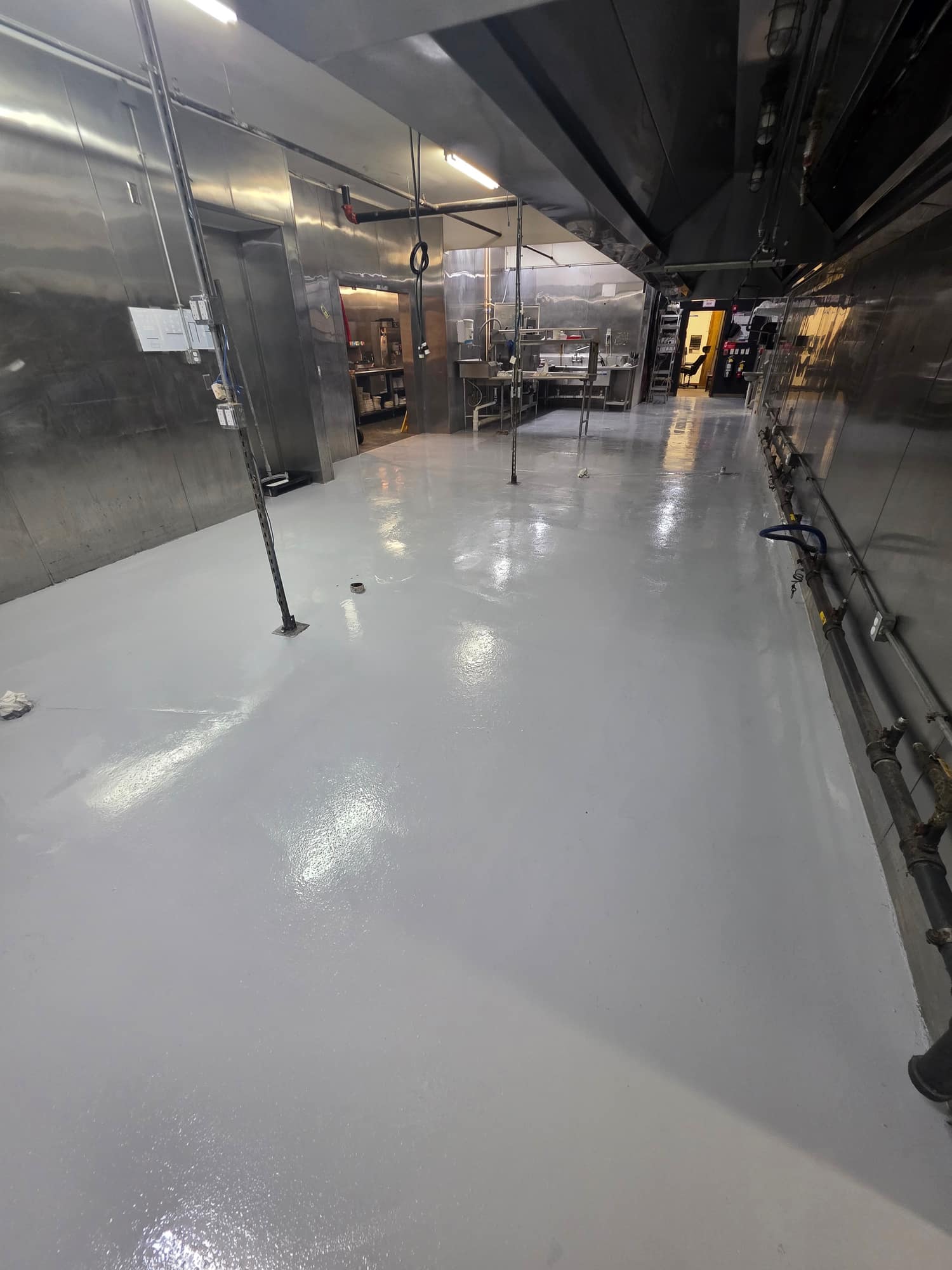 Solid color coated floor running the length of a commercial kitchen line