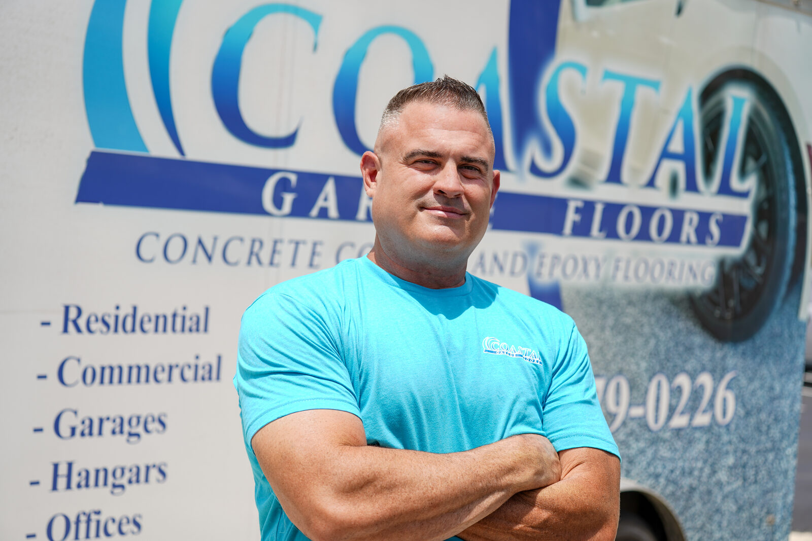 Ryan, owner of Coastal Garage Floors, in front of the company trailer